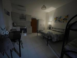 a bedroom with a bed and a table and a kitchen at Ortensia Apartment in Giungano