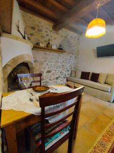 a dining room with a table and a fireplace at Thelya - Stone House in Apóllona