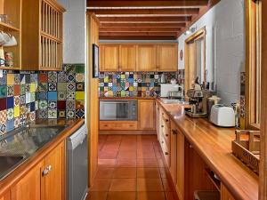 a kitchen with wooden cabinets and a tile floor at Ridge River Retreat in Merrijig