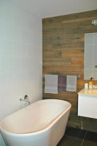 a white bath tub in a bathroom with a sink at Moodemere Lake House in Rutherglen