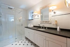 a bathroom with a sink and a shower at Le Vieux Moulin Weywertz in Butgenbach +40 photos