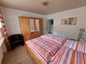 una camera da letto con un letto e una sedia di Ferienwohnung Arendt inkl MeineCardPlus a Willingen