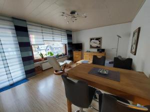 una sala da pranzo con tavolo e sedie in legno di Ferienwohnung Arendt inkl MeineCardPlus a Willingen