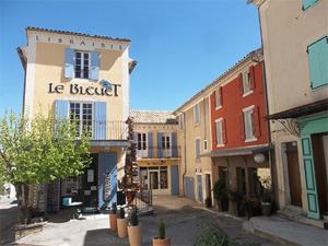 a group of buildings on a street in a town at plein coeur de BANON in Banon