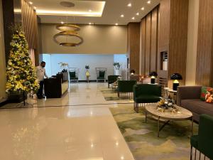 a man standing in a lobby with a christmas tree at Modern 1BR with Balcony Facing Infinity Pool Manila Bay Sunset Near Airports OKADA Solaire MOA in Manila +77 photos