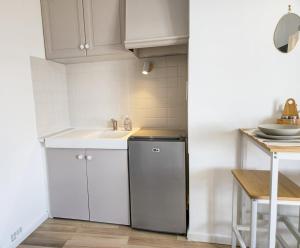 a white kitchen with a sink and a dishwasher at Cocon pour 2 - vue sur le clocher in Moustiers-Sainte-Marie
