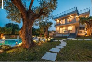 a house with a tree next to a swimming pool at Micabalù Luxury Apartment in Marina di Camerota