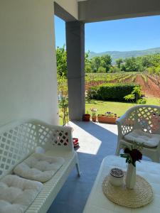a patio with two white chairs and a table at Rooms Nikola Rule Ostojic in Međugorje