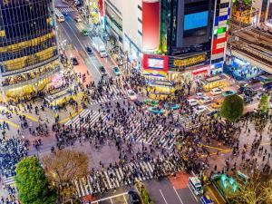 a crowd of people crossing a busy city street at APA Hotel Shibuya Dogenzakaue in Tokyo