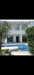 a large house with a swimming pool in front of it at Villa Hélène in Nianing