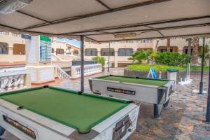 a pool table on a patio in front of a building at Castle Harbour with heated pool ap Patricia in Los Cristianos