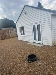 a house with a tire on the ground in front of it at Adorable Self Contained detached annexe in Holmwood