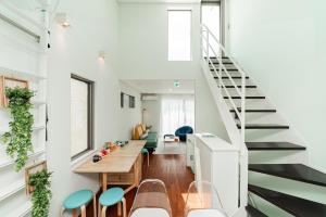 a room with a staircase and a table and chairs at Roppongi House in Tokyo