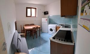a small kitchen with a table and a washing machine at Monolocale centro!! in Palinuro