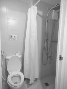 a bathroom with a toilet and a shower with a shower curtain at Condo unit in Manila
