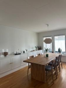 a white kitchen with a wooden table and chairs at large Villa In Central Motala in Motala +7 photos