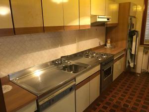 a kitchen with a stainless steel sink and a stove at Appartamento mare in Cesenatico