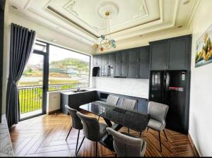 a kitchen with a table and chairs in a room at Villa Thanh Thanh in Da Lat