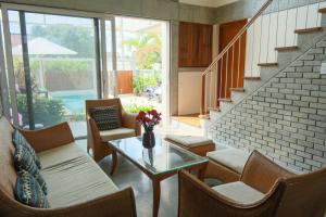 a living room with chairs and a table and stairs at Marvelous Homestay Hoi An in Dien Ban