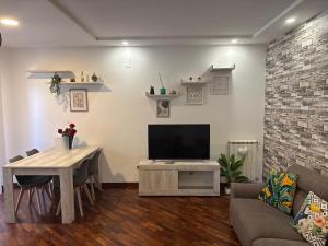 a living room with a tv and a table and a couch at Casa ViDì Fiumicino in Fiumicino Airport