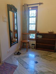 een kamer met een spiegel, een stoel en een raam bij the Kutumb- Where the Himalayas come alive! in Pālampur +27 foto's