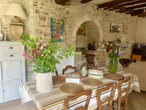 a table with chairs and vases with flowers on it at Les ambiances du Coly in Condat-sur-Vézère