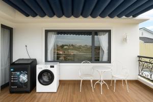 a room with a washing machine and a table and chairs at Villa Thanh Thanh in Da Lat
