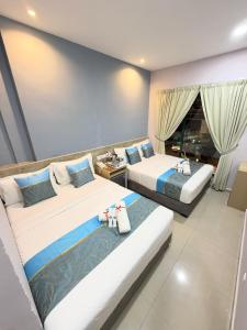 a bedroom with two beds and a couch at AQ Hotel Kuala Lumpur in Kuala Lumpur