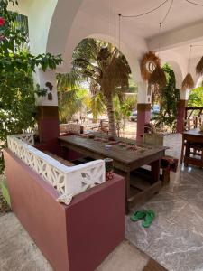 a patio with a table and a palm tree at Darwesh Nyumba Lodge in Nungwi