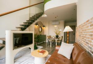a living room with a couch and a fireplace at Leng - Duplex Onsen Swanlake Ecopark in Kim Quan