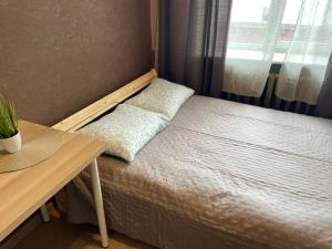 a bed in a room with a desk and a window at Kopli Apartment in Tallinn