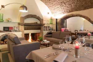 a restaurant with a fireplace and tables and chairs at Antica Dimora Del Gruccione, Albergo diffuso in Santu Lussurgiu