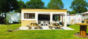 two picnic tables in front of a tiny house at Caravane vintage in Camoël