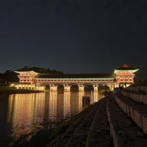 a building with a bridge over a river at night at KIM's HOUSE in Gyeongju