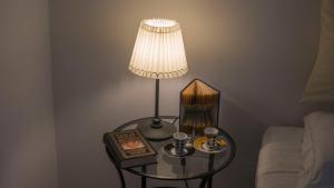 a lamp on a table next to a bed at Domus 21 - DIEMME STAY in Alberobello