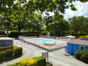a swimming pool with a fence around it at Caravane vintage in Camoël