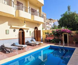 a villa with a swimming pool and a house at Villa Belzoni in Luxor
