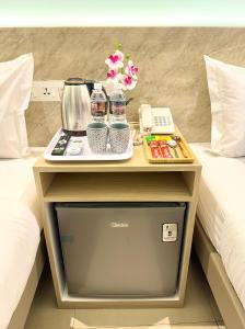 a nightstand with a tray on top of a bed at AQ Hotel Kuala Lumpur in Kuala Lumpur