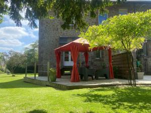 a red tent on a deck in a yard at La Jackal in Ploubezre