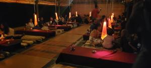 a group of people sitting in a room with candles at Monkey Paradise Hampi in Hampi