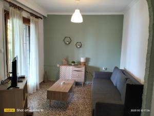 ein Wohnzimmer mit Sofa und Couchtisch in der Unterkunft Με Θεα!! in Stomio