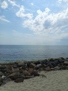un gruppo di rocce su una spiaggia vicino all'acqua di Ваканционен Апартамент ad Aheloy
