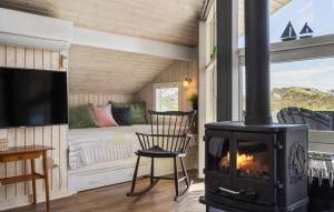 a fireplace in a tiny house with a bed at Holiday Home Bjerregårdsvej Hvide Sande in Bjerregård