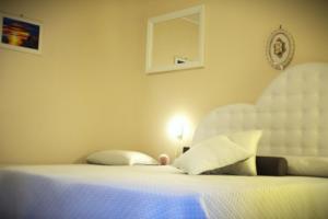 a bedroom with a white bed with a white headboard at B&B Stupor Mundi in Altamura