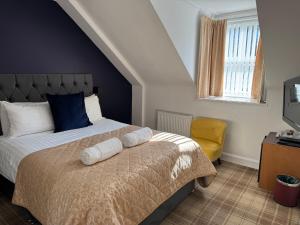 a bedroom with a bed and a yellow chair at Sandvilla Guesthouse in Oban