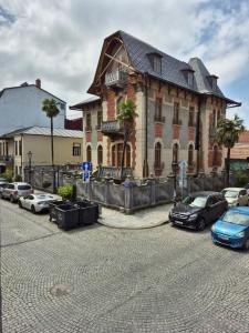 un grande edificio in mattoni con auto parcheggiate in un parcheggio di Apartment Giorgi Mazniasvhili a Batumi