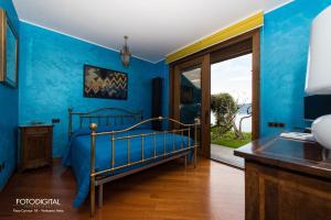 1 dormitorio con paredes azules, 1 cama y escritorio en B&B Renalù, en Verbania
