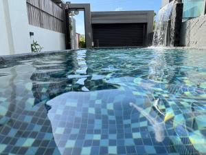 a swimming pool with a fountain in front of a building at 月出悠悠Moon Rise未與阿勾達合作電聯付訂才算預訂完成 in Hengchun South Gate