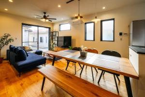 宫古岛M'z Villa的带桌子的客厅和餐厅