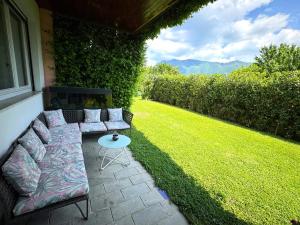a patio with a couch and a table on a lawn at Casa Natura in Cernobbio